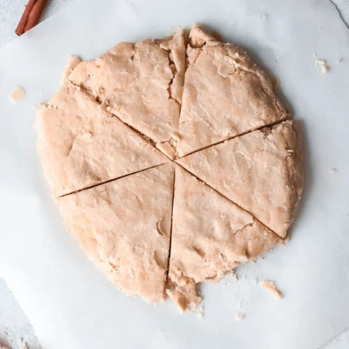 Scone dough patted into a six-inch disc and cut into eight wedges