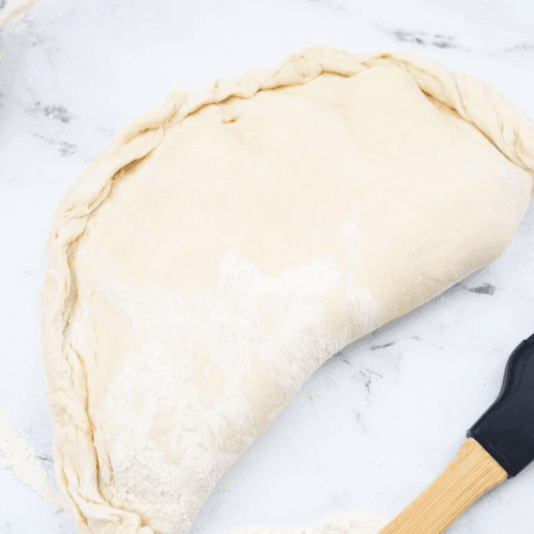 Air fryer preheated to 350°F, calzone cooking until crispy and golden brown.
