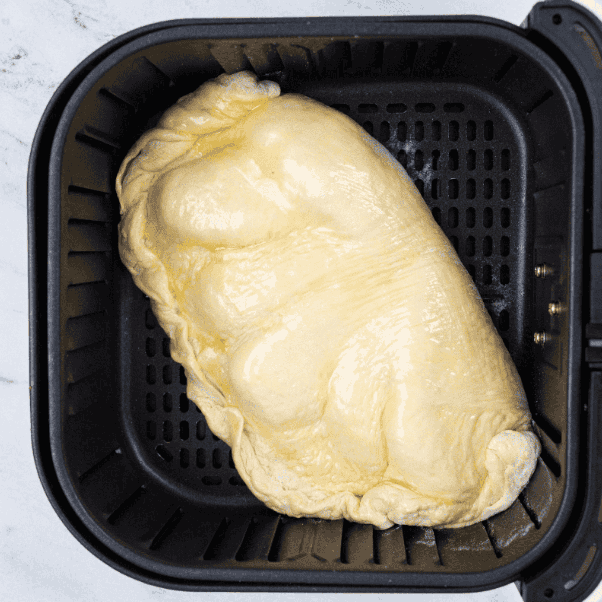 Air fryer set to 350°F with a calzone inside, cooking to golden perfection.