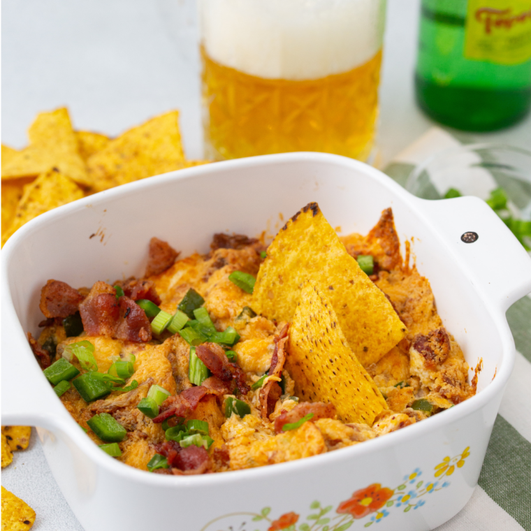 Finished air fryer jalapeño popper dip garnished with scallions, jalapeño rings, and crumbled bacon, ready to serve