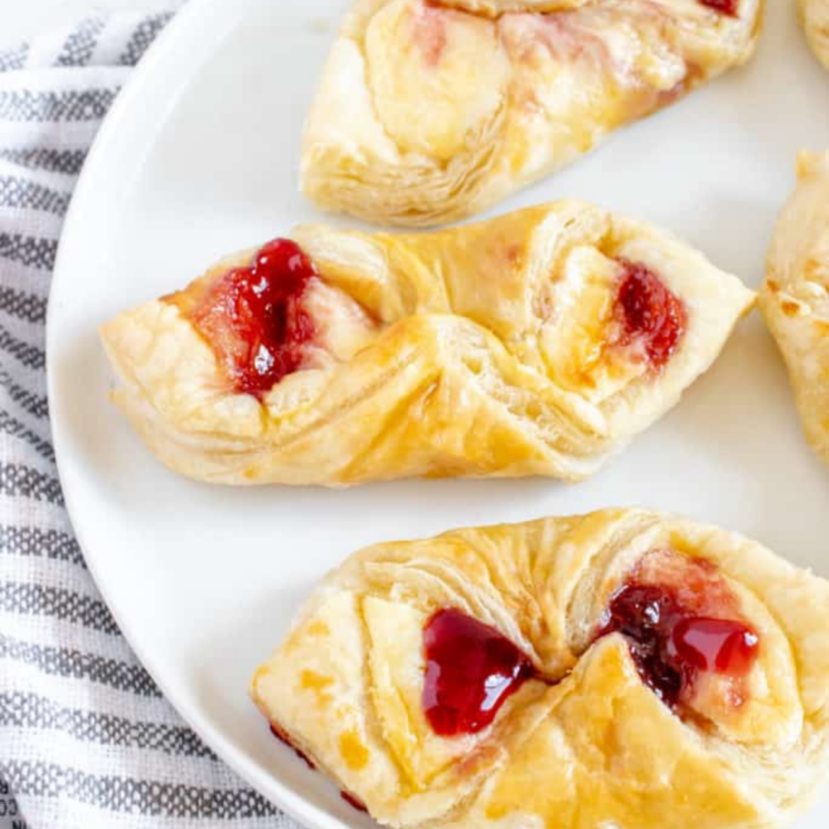 Plate of golden air fryer puff pastry Danish with raspberry jam centers