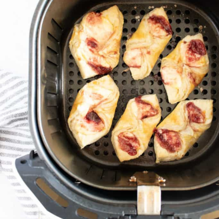 Air fryer puff pastry Danish drizzled with vanilla glaze on a wire cooling rack