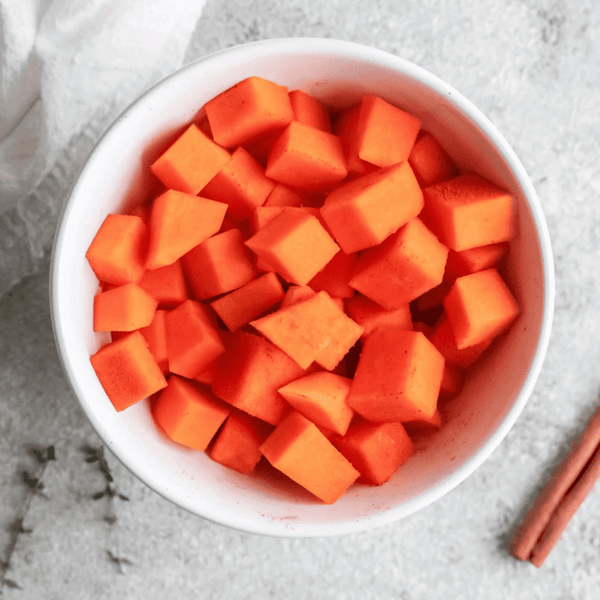 Diced air fryer roasted pumpkin with crispy caramelized edges in a white bowl, seasoned with smoked paprika and cinnamon