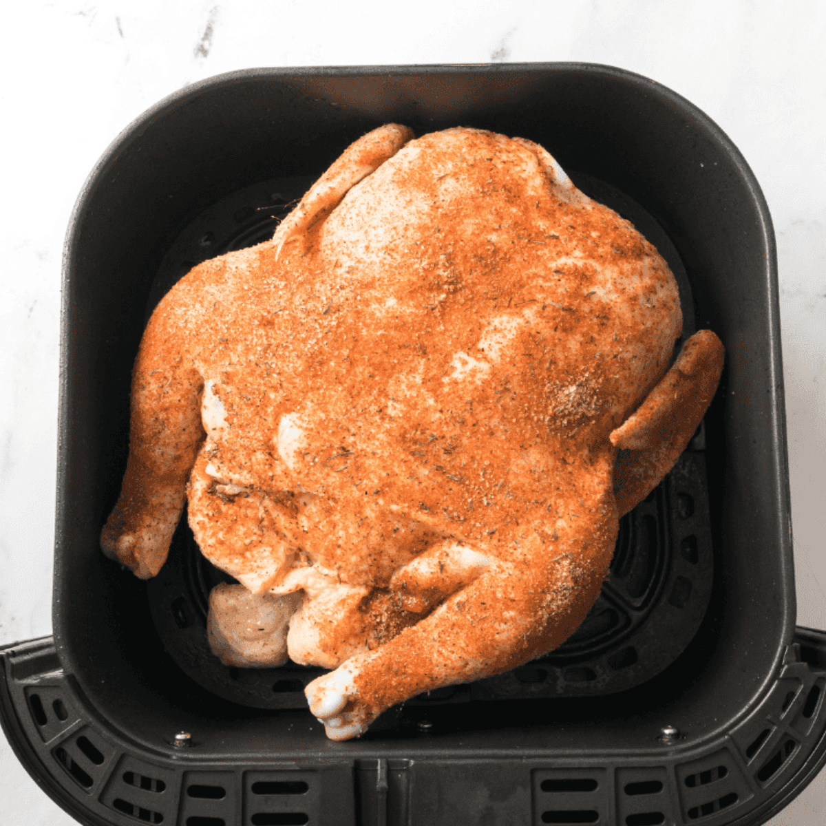 Seasoned chicken resting on a plate for 10-15 minutes to allow flavors to soak in.