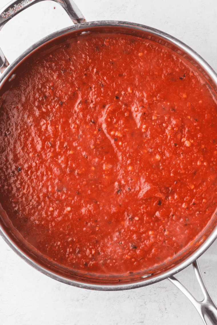 Homemade Little Caesar’s style pizza sauce in a bowl, ready to spread on pizza.