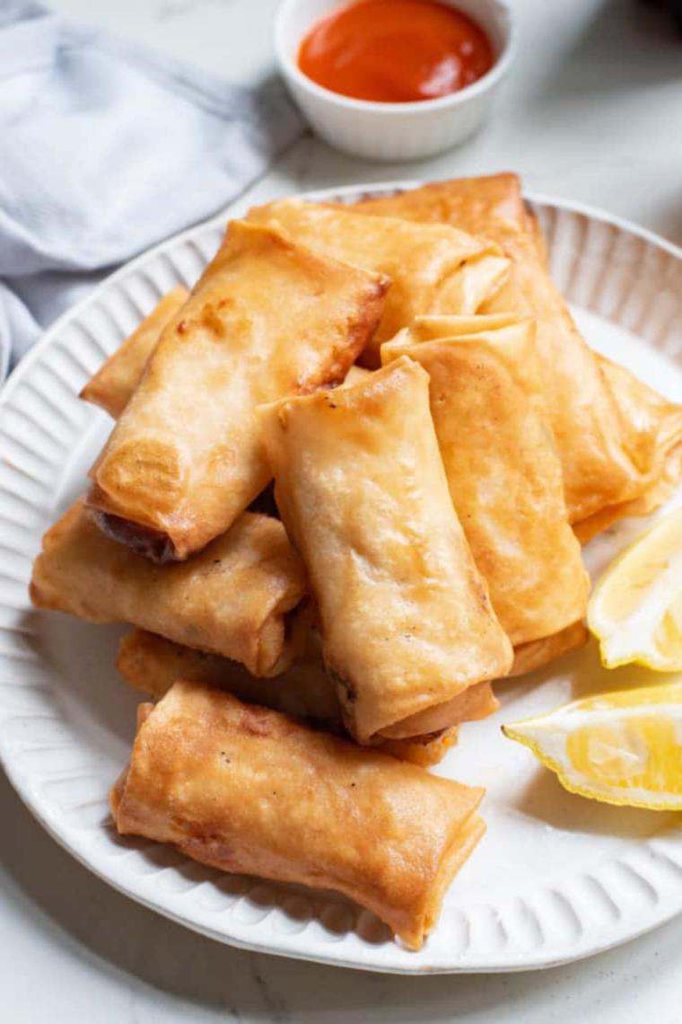 Air Fryer Copycat Panda Express Chicken Egg Rolls on plate with dipping sauce in the background.