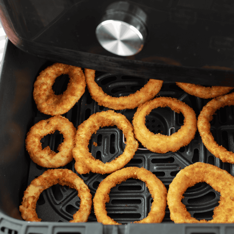 Frozen Red Robin onion rings arranged in a single layer in the air fryer basket before cooking