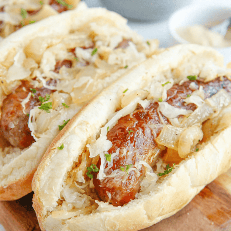 Air fried frozen brats in an air fryer basket, browned with blistered casings