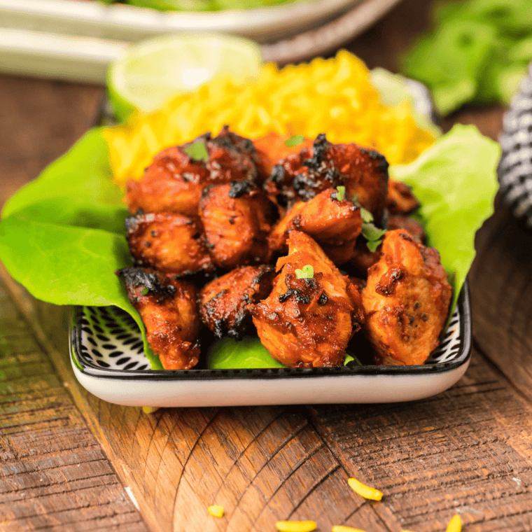 Plate of air fryer BBQ chicken bites with glossy barbecue sauce.
