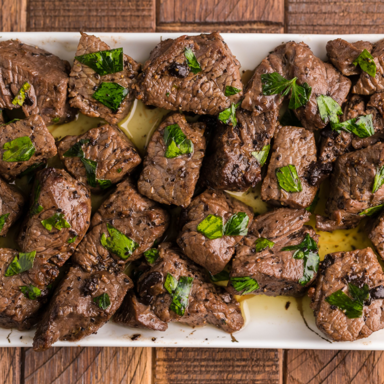 Juicy steak bites tossed in garlic butter sauce, freshly cooked in an air fryer with a crisp seared exterior.