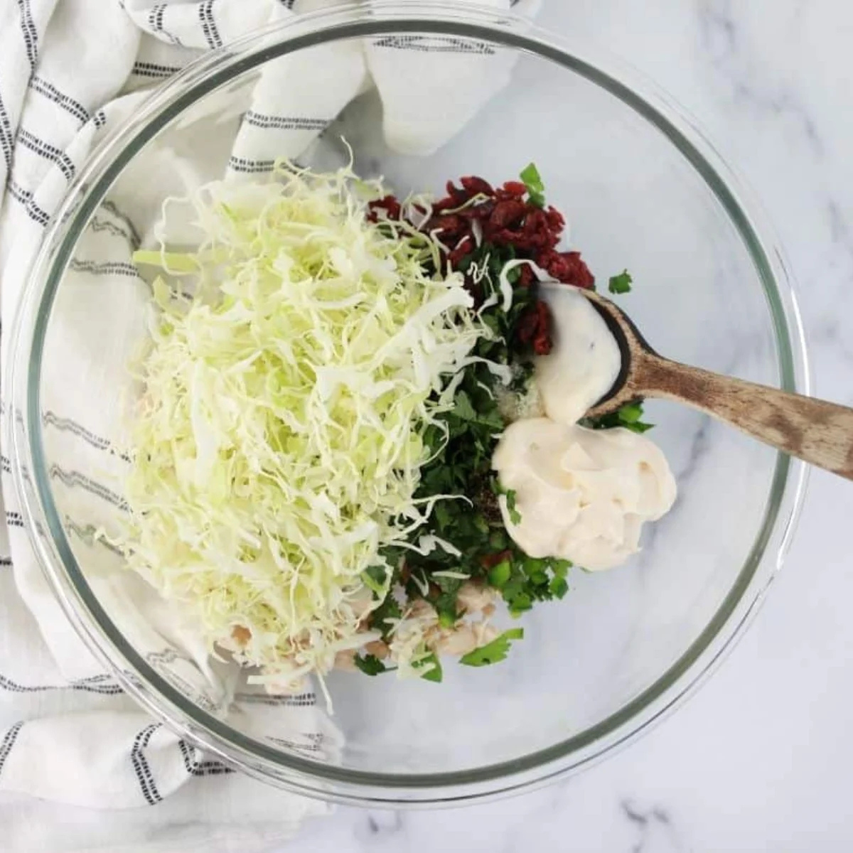 Chicken cilantro egg roll filling mixed in a glass bowl with cranberries visible throughout