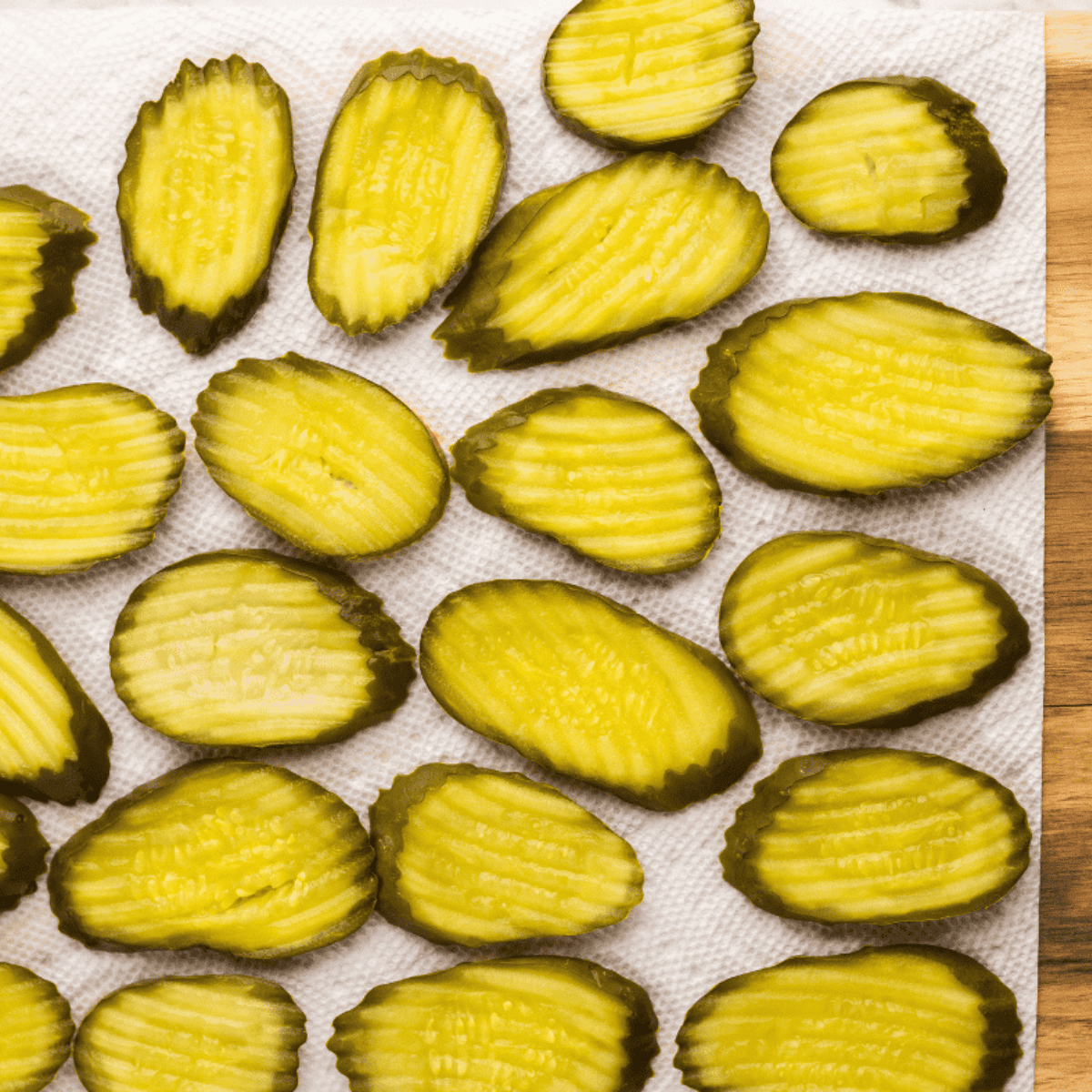 Dill pickle chips pressed between paper towels to remove moisture before breading