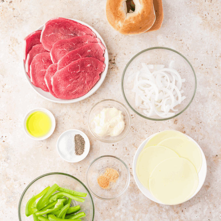Ingredients needed for Easy Ribeye Steak Sandwich with Grilled Onions on kitchen table.