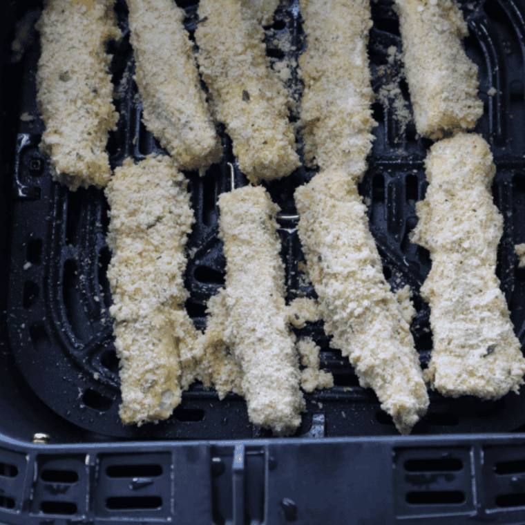 Place coated eggplant fries in air fryer, spray with oil, cook at 400°F, flipping halfway.