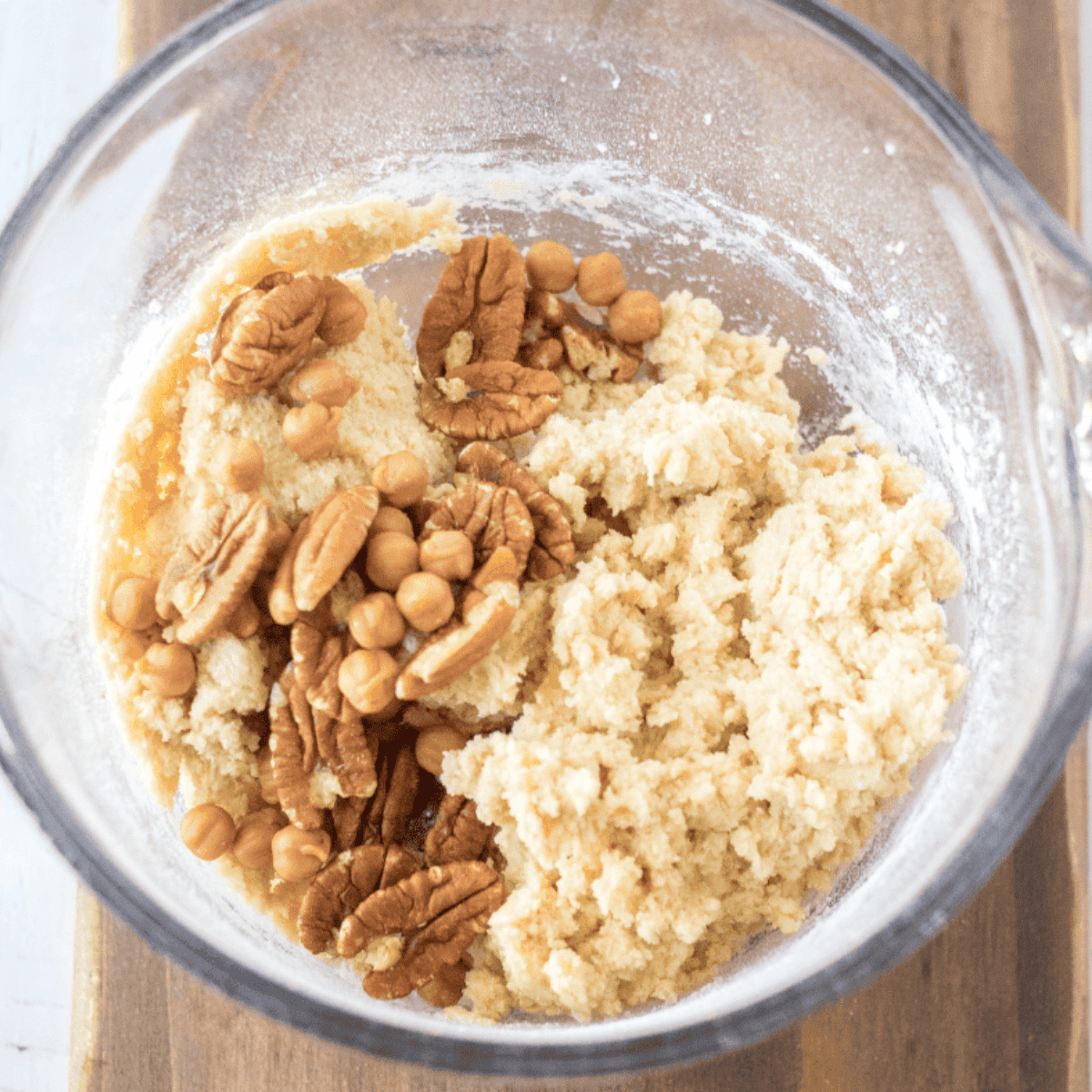 Mixing bowl with butter, sugars, egg, vanilla, flour, pecans, and caramel bits being combined for a giant caramel pecan cookie.