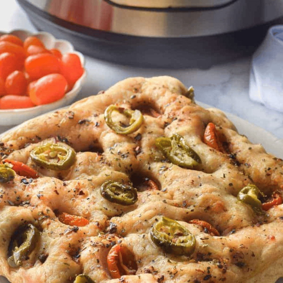 Golden, fluffy focaccia bread fresh from the Instant Pot, topped with herbs and ready to serve.