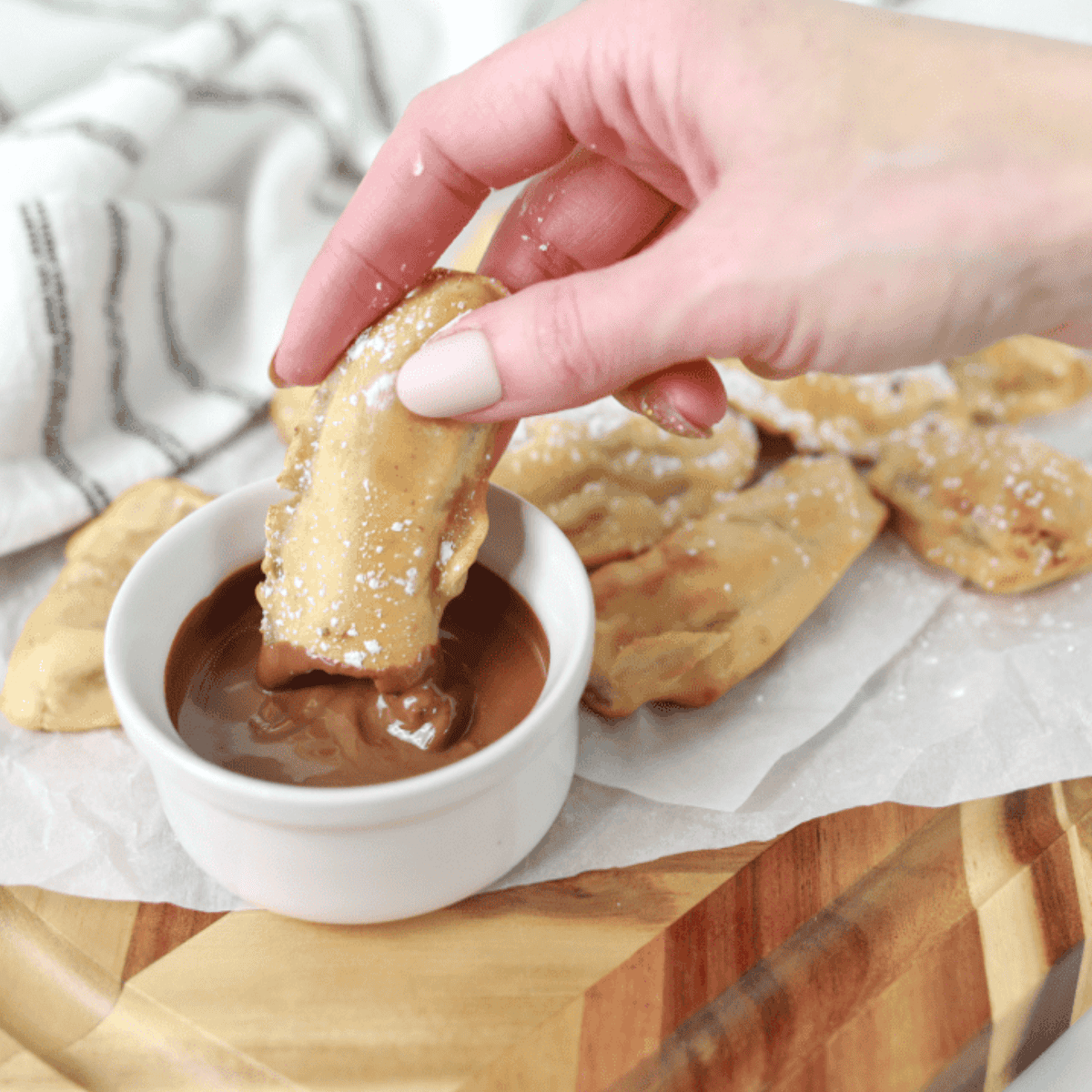 Air Fryer Banana Pancake Dippers on parchment, golden brown and ready to serve with chocolate or maple syrup.