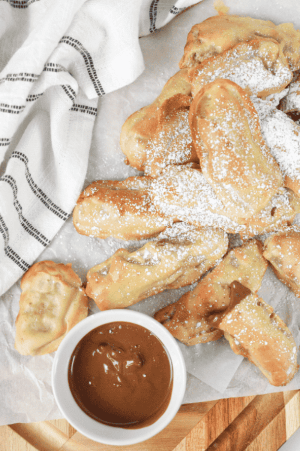 Golden Air Fryer Banana Pancake Dippers stacked on a plate, served with melted chocolate for dipping