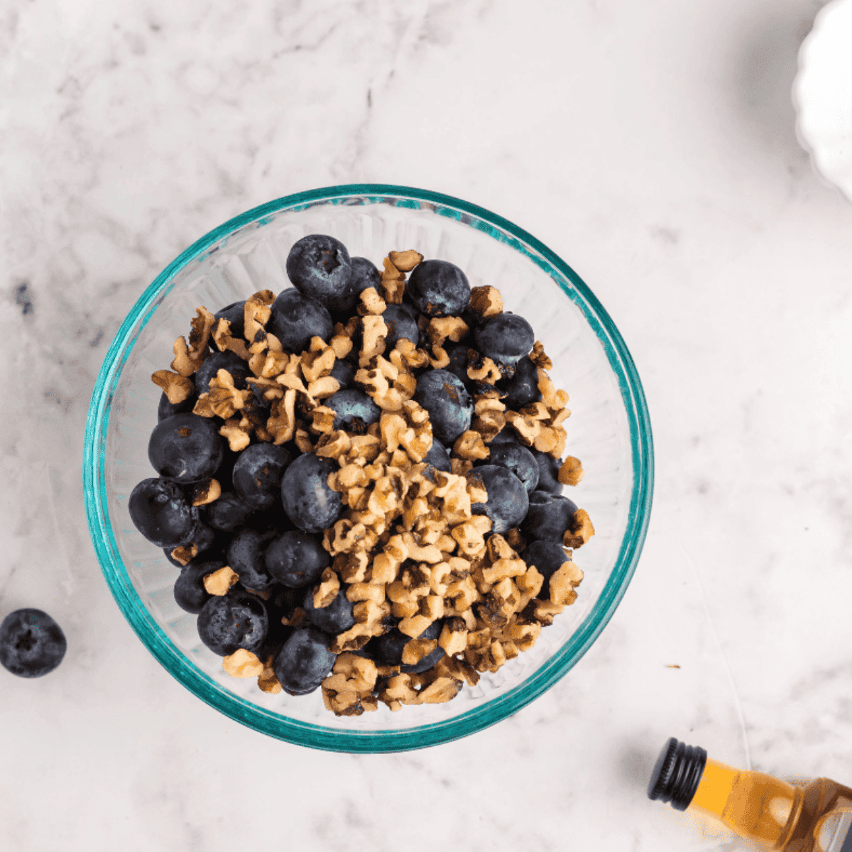 Blueberries, walnuts, and bourbon soaking together in a bowl before baking