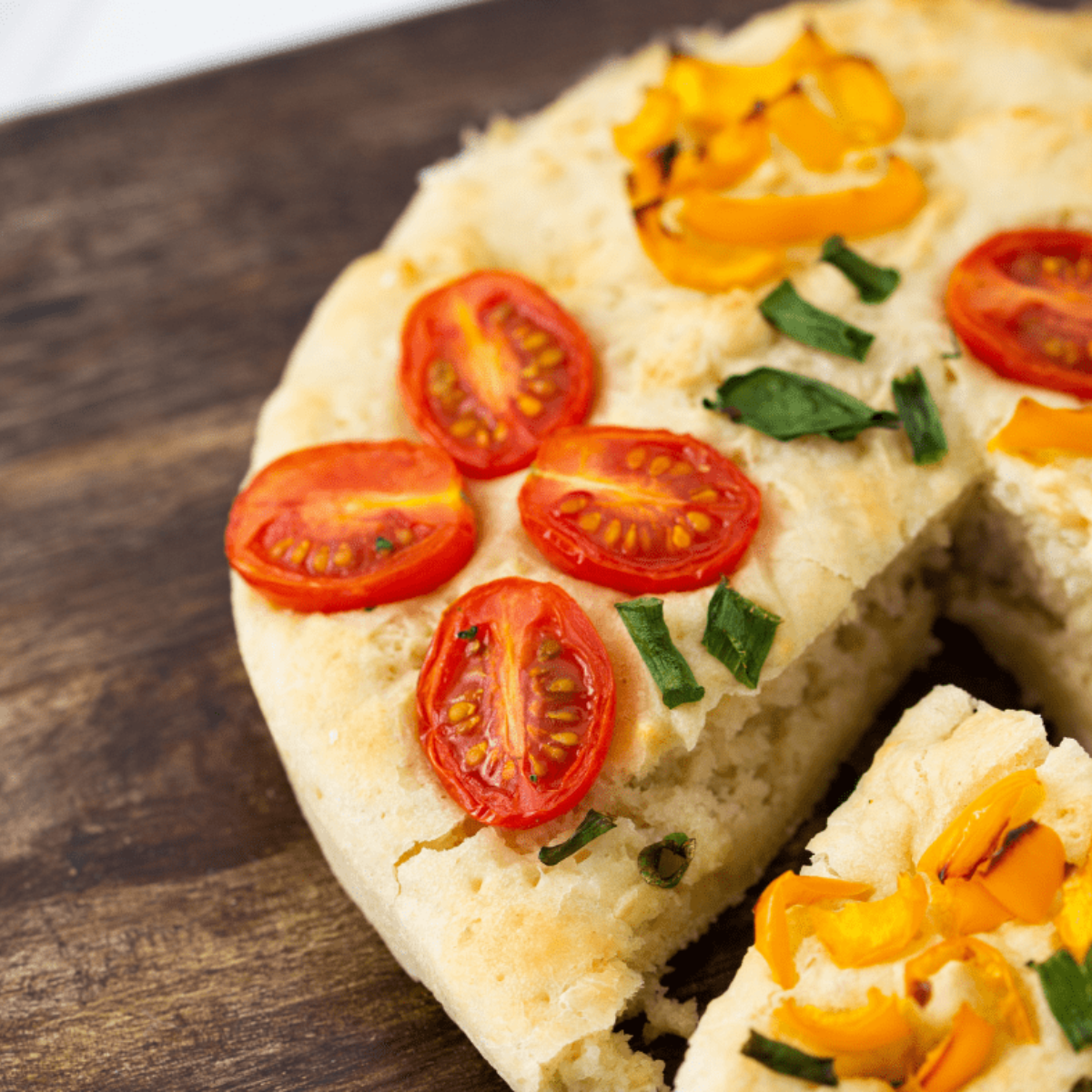 Air fryer garden focaccia with golden crust, cherry tomatoes, fresh herbs, and colorful vegetables