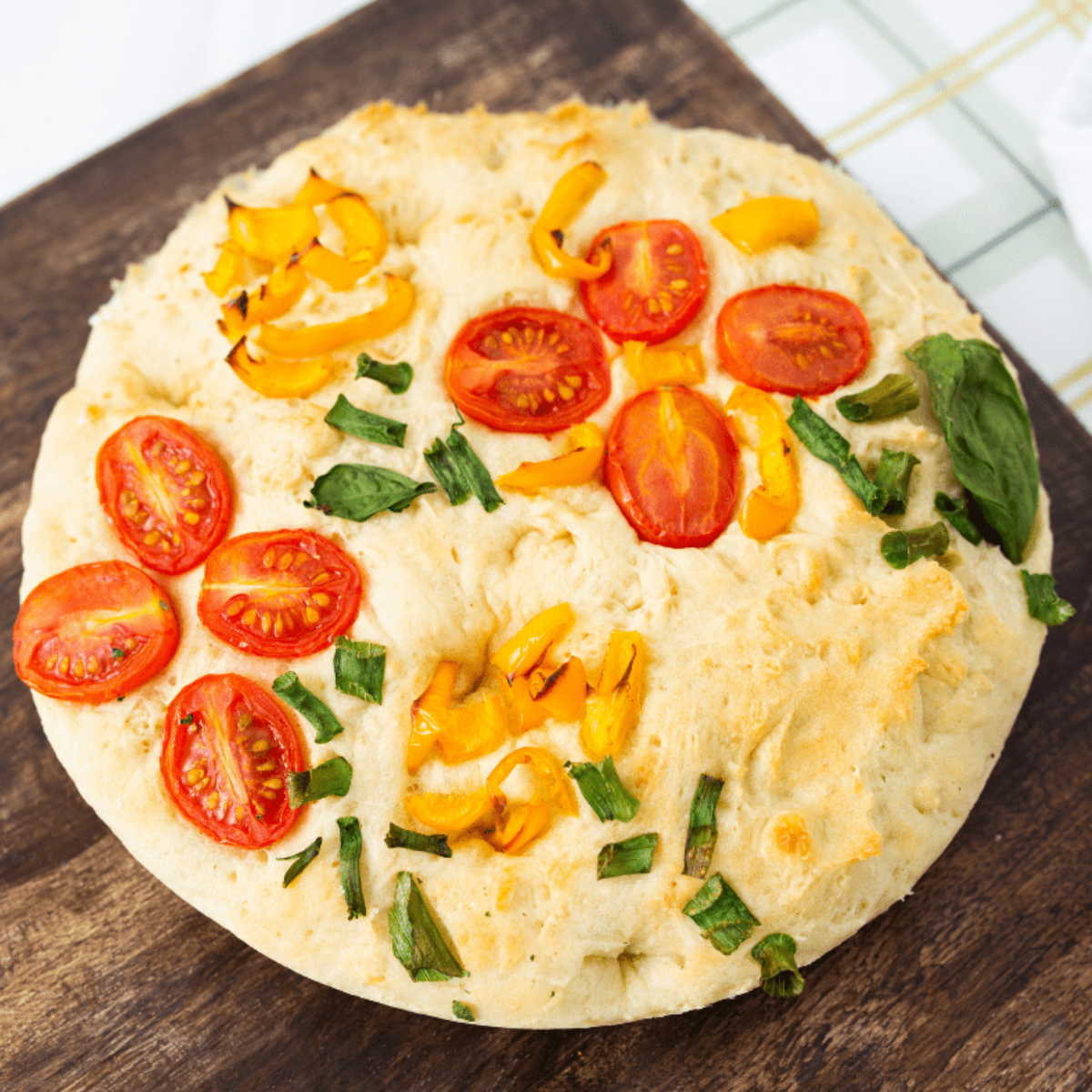 Air fryer garden focaccia bread with golden crust, fresh herbs, and cherry tomatoes