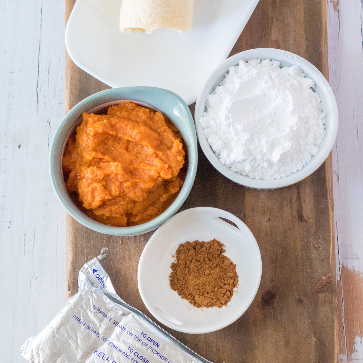 Ingredients for pumpkin cheesecake donut holes: crescent rolls, cream cheese, canned pumpkin, and powdered sugar