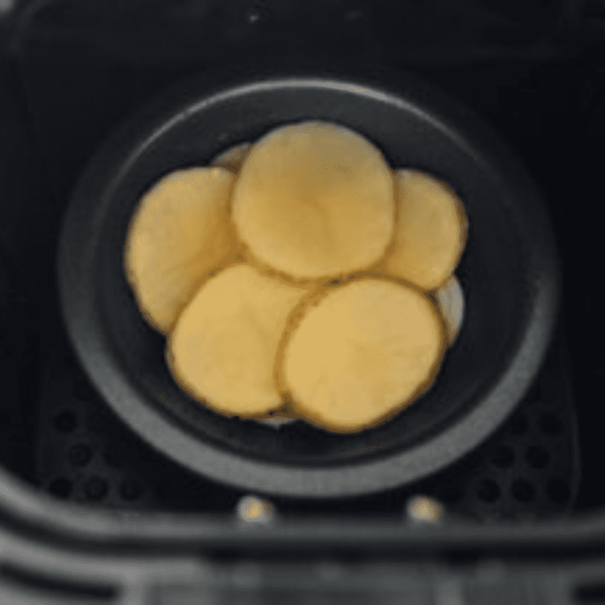 Sliced potatoes and onion layered in ramekins before air frying