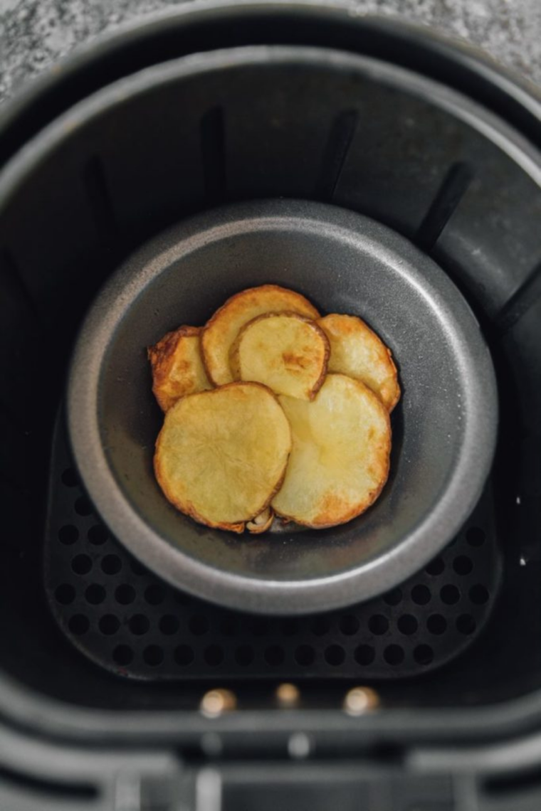 Beaten eggs poured over cooked potatoes in air fryer tins