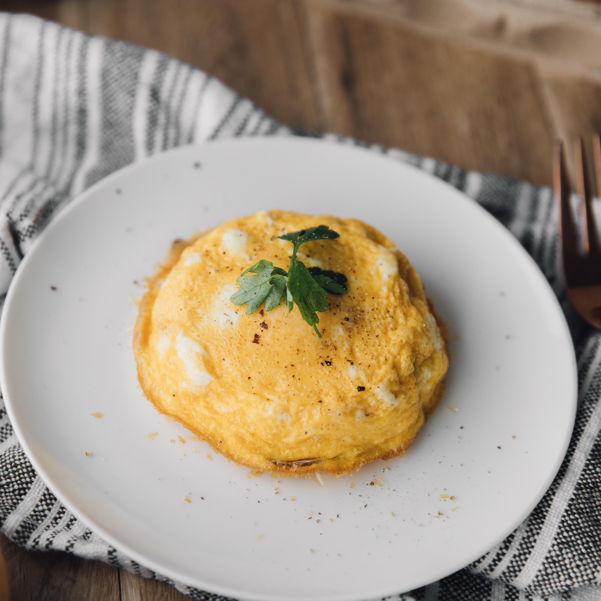 Air fryer Spanish tortilla on a white plate topped with chopped parsley