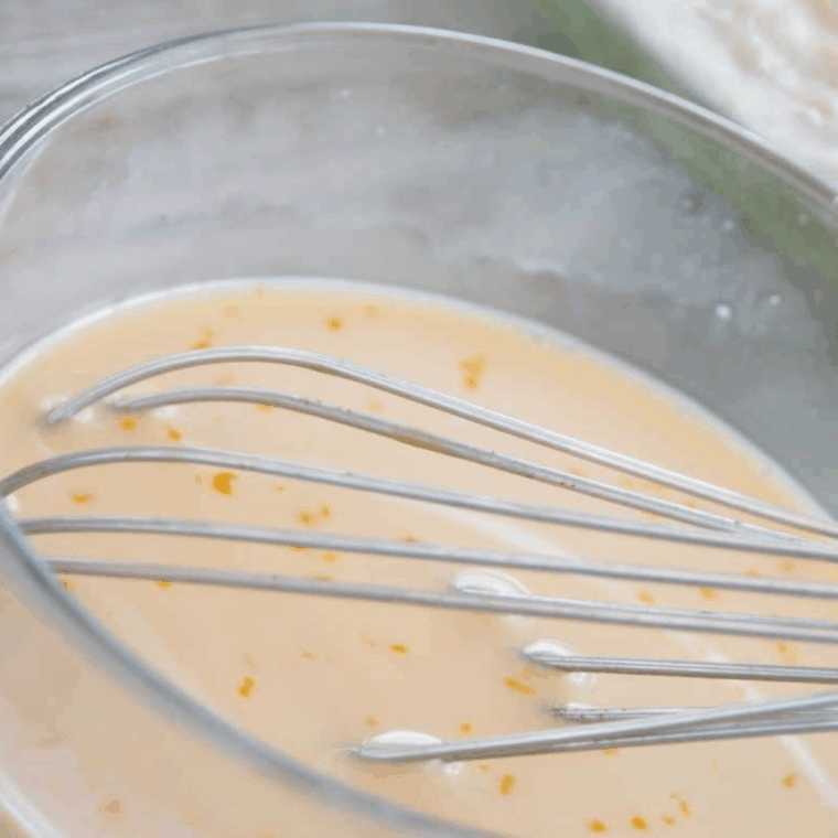 Small bowl with egg, milk, and vanilla extract being mixed, then combined with dry ingredients to form dough.