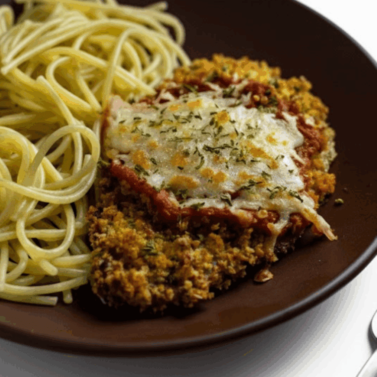 Crispy, golden brown breaded veal cutlets fresh out of the air fryer on a serving plate.