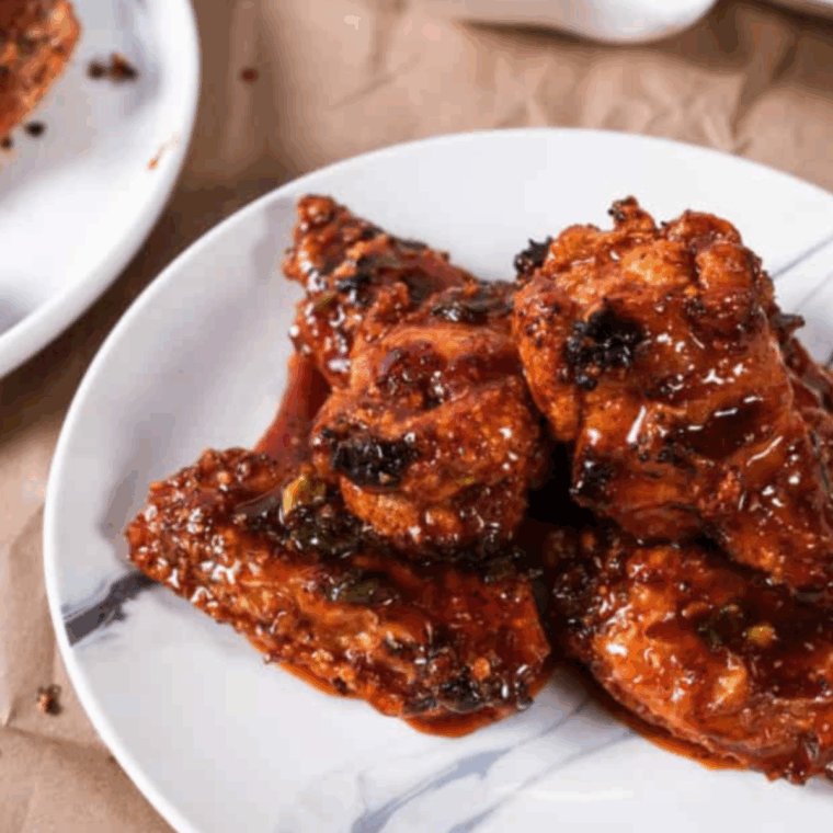 Plate of Air Fryer Korean Chicken Wings garnished with sesame seeds and green onions