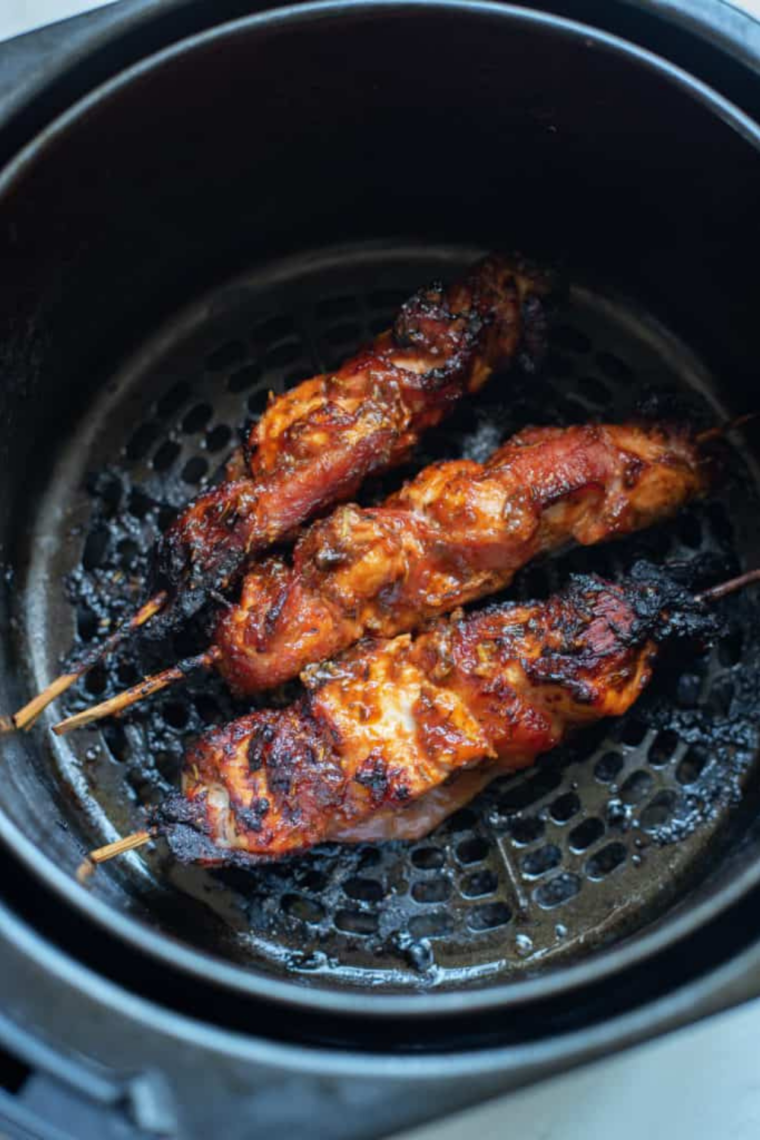 Crispy bacon wrapped chicken tenders after air frying until golden