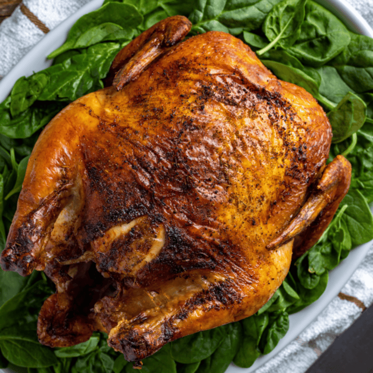 Whole beer can chicken cooked in an air fryer with golden crispy skin and juicy roasted meat inside.