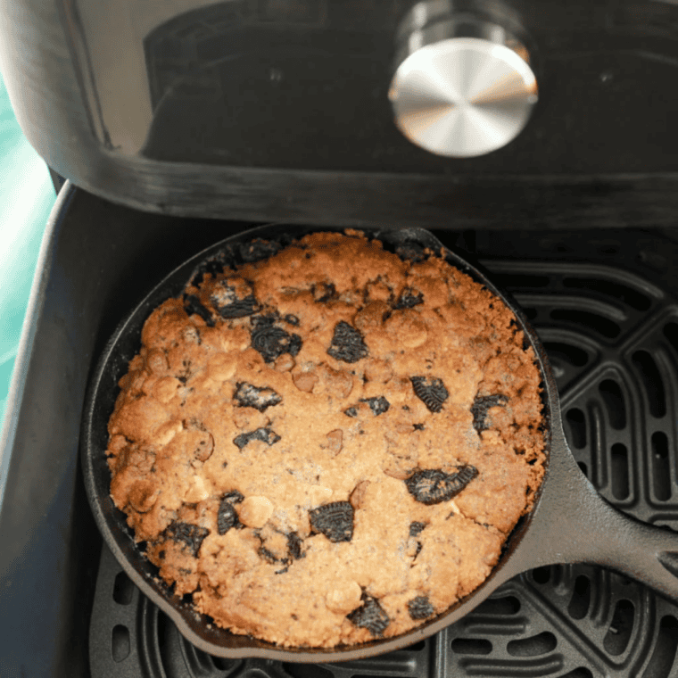 Air fryer basket with cookie dough pan inside, ready to cook at 320°F.