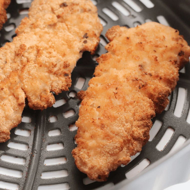 Crispy air fryer cornbread crusted chicken tenders resting on a wire rack
