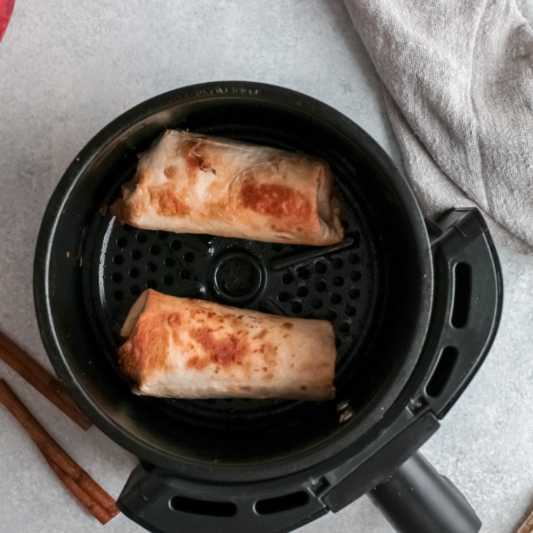 Golden brown apple flautas in the air fryer basket after cooking