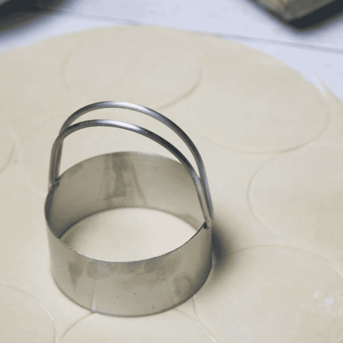 Cutting pie crust into circles with a 4-inch biscuit cutter