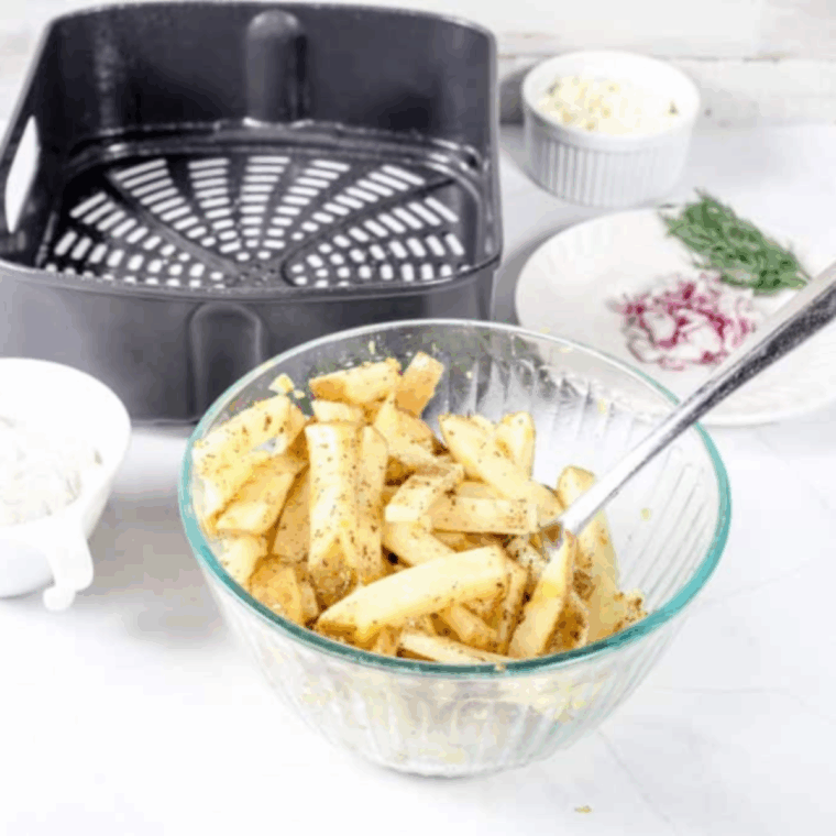 Potatoes cut into quarter-inch fries soaking in a bowl of cold water before air frying