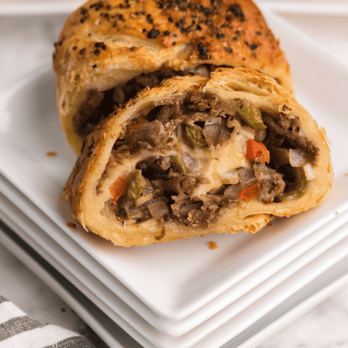 Golden-brown Air Fryer Italian Beef Stromboli sliced open, showing melted cheese and seasoned Italian beef inside.