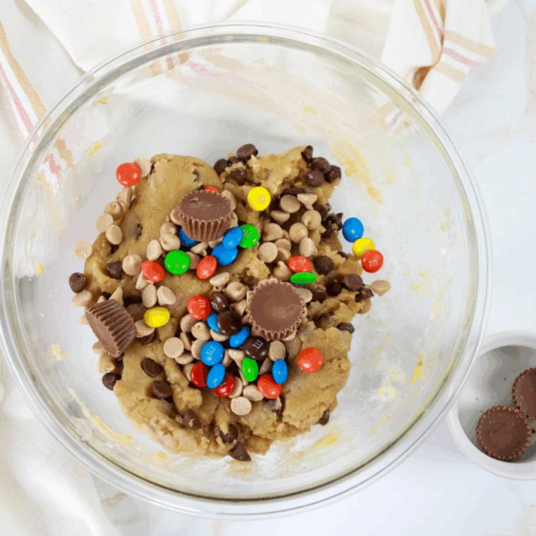 Dough mixed thoroughly with chocolate chips, peanut butter chips, peanut butter M&M's, and Mini Reese Cups folded in