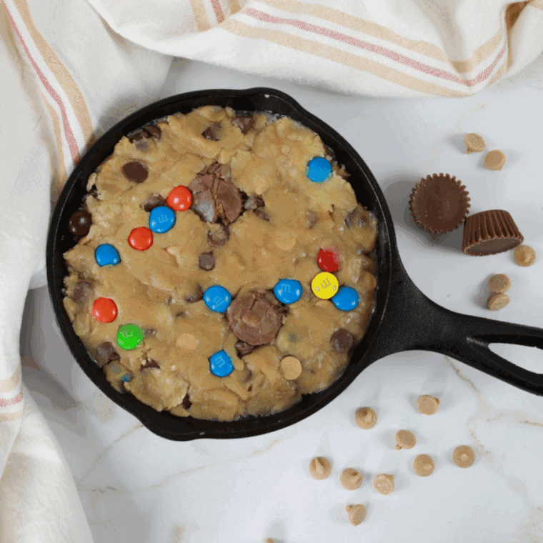 Cookie dough pressed into a greased pan with add-ins evenly distributed