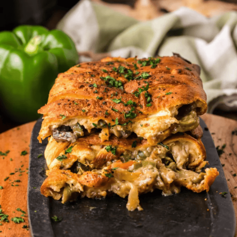 Crispy Easy Air Fryer Vegan Philly Wrap stuffed with plant-based steak, sautéed peppers, and onions, sliced and ready to eat.