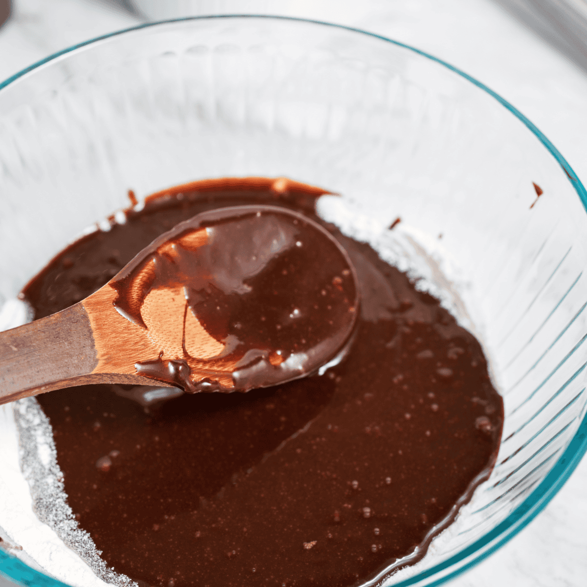 Adding flour to brownie batter and stirring gently until just combined to keep the texture soft and fudgy without overmixing.