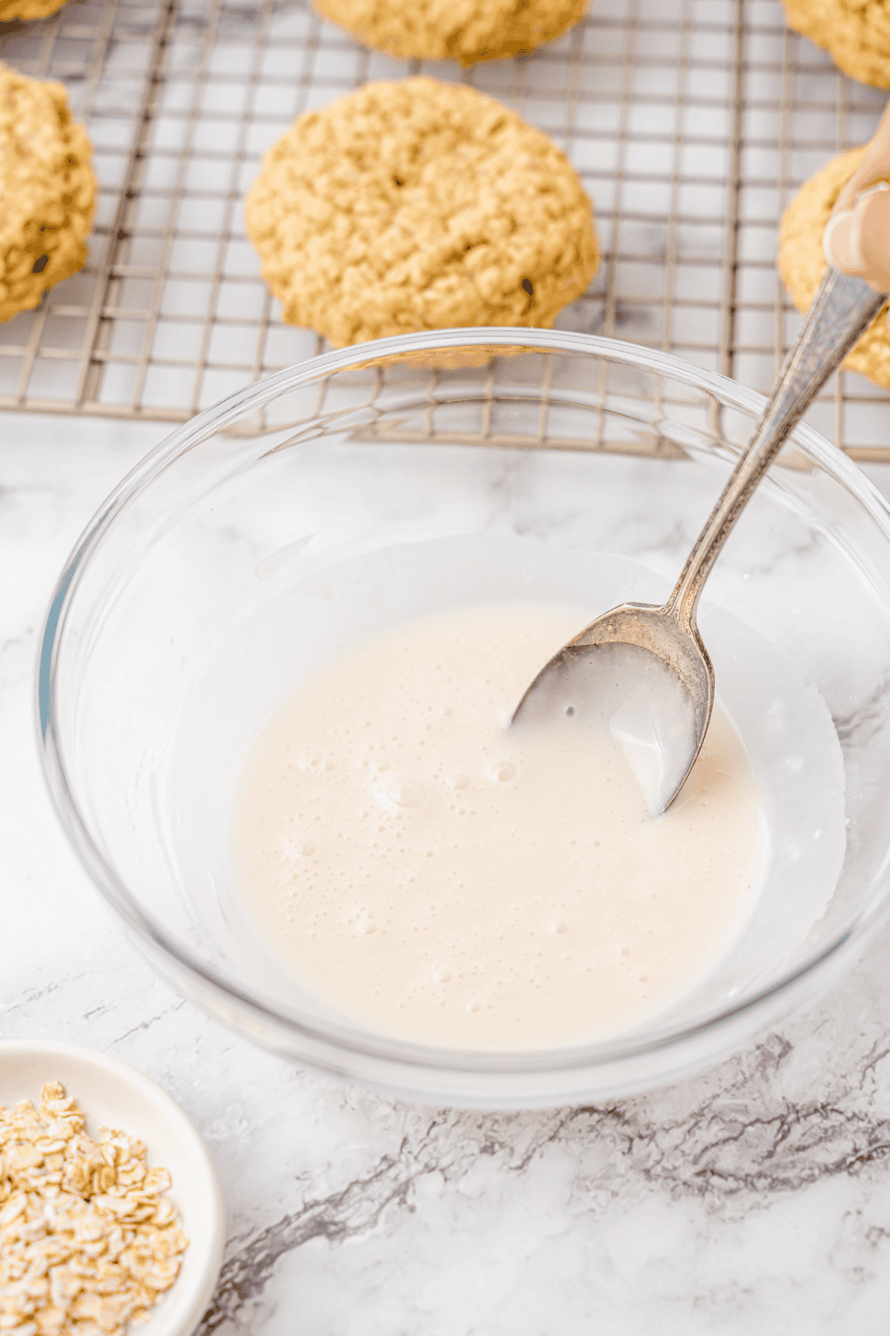 Mixing powdered sugar, milk, and vanilla in a small bowl to make icing.