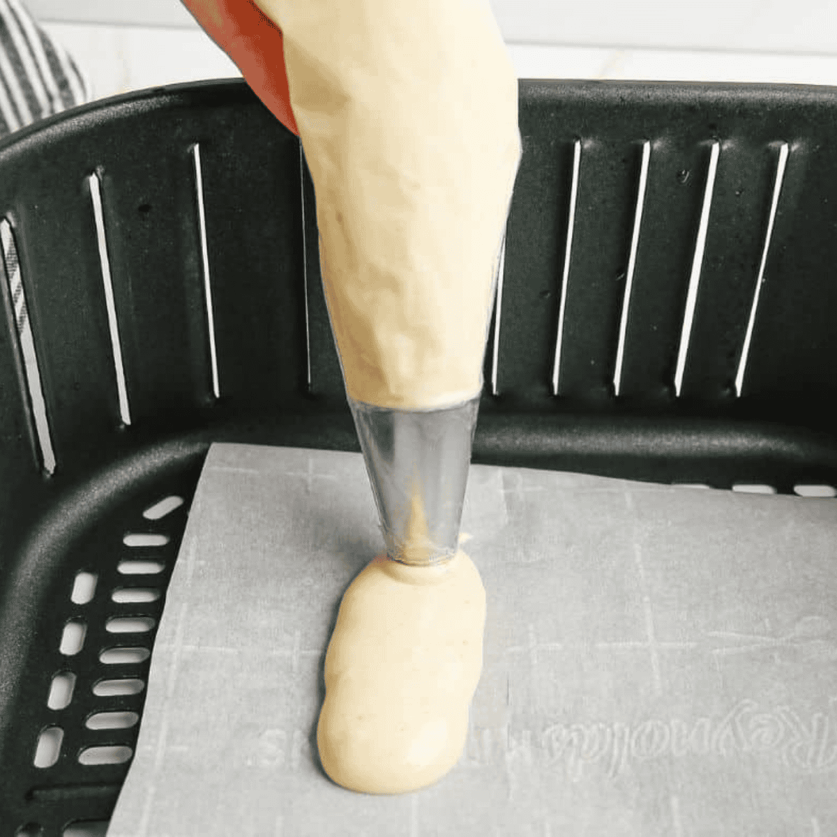Piping light and airy ladyfinger batter into 3–4 inch strips on parchment-lined air fryer tray.