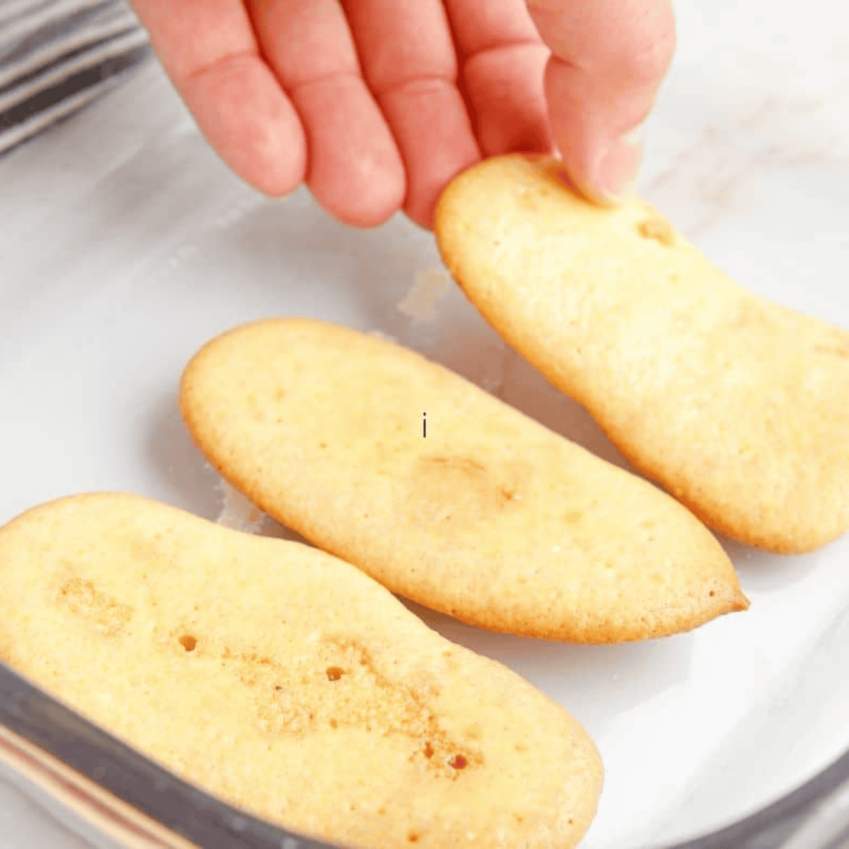 Freshly baked homemade ladyfingers, golden and crisp, straight from the air fryer on a cooling rack.
