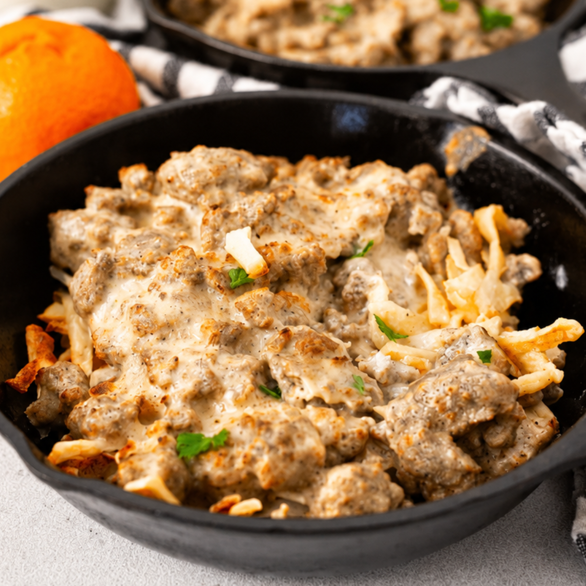 Air fryer sausage gravy breakfast skillet served on a plate, crispy hash browns topped with creamy homemade sausage gravy