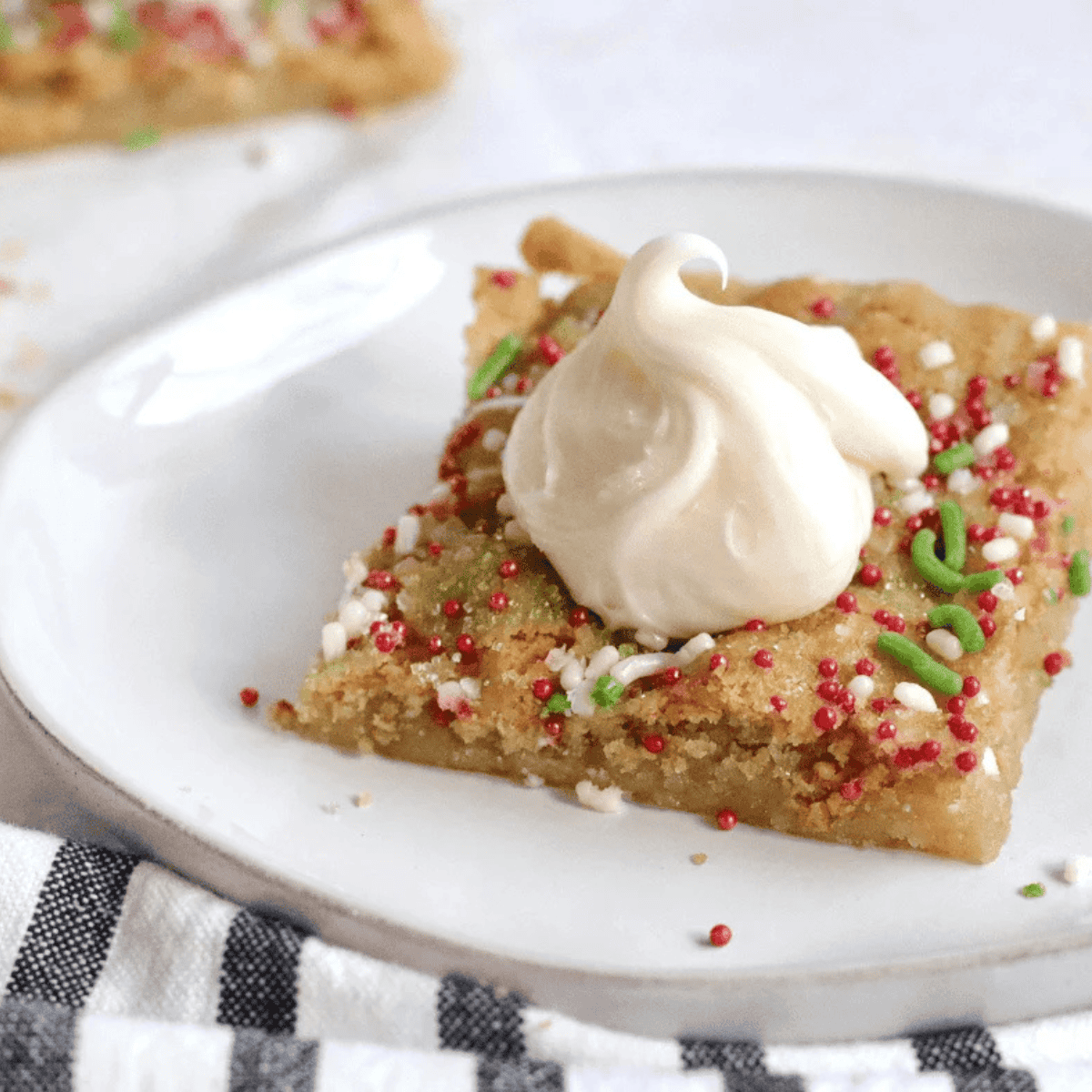 Air fryer sugar cookie bars topped with frosting and colorful sprinkles, ready to serve.