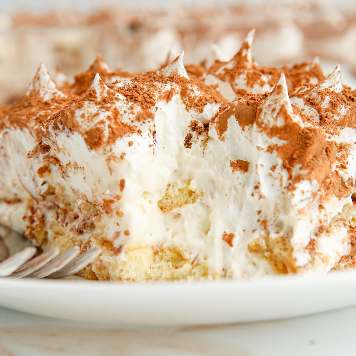 Square of air fryer tiramisu plated and dusted with cocoa, ready to serve
